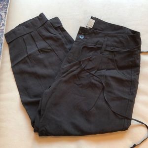 ecru black pleat front cropped pants with cuffed hems.